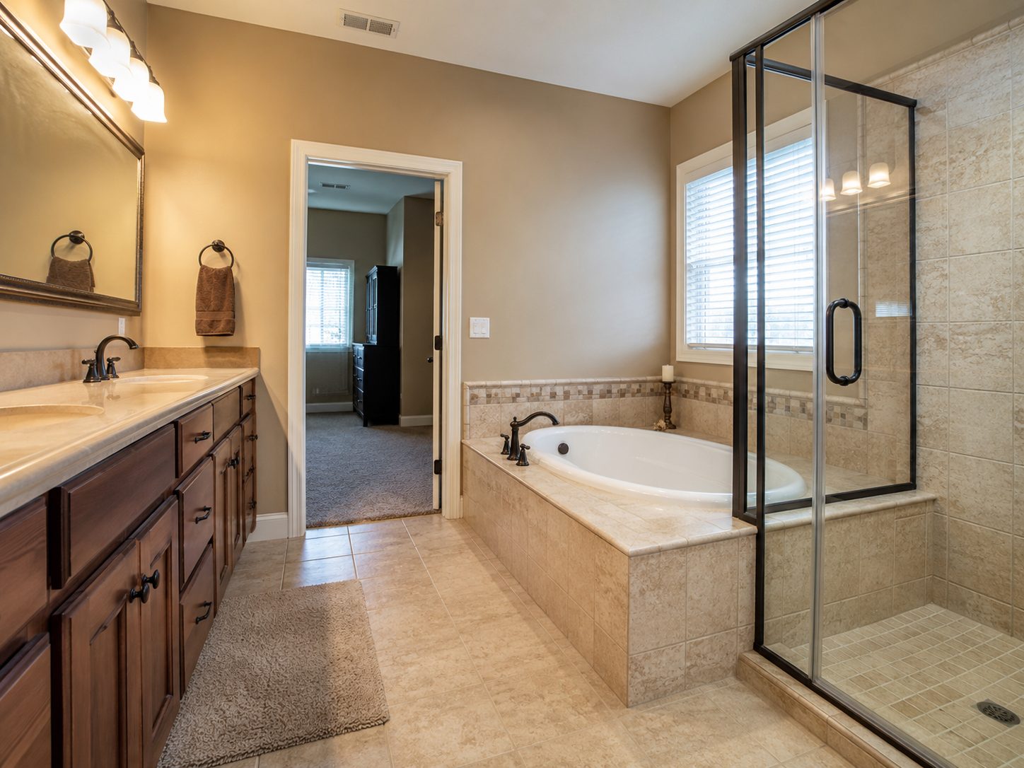 Bathroom before remodel with beige tile and dark wood vanity, Dreamliner Construction