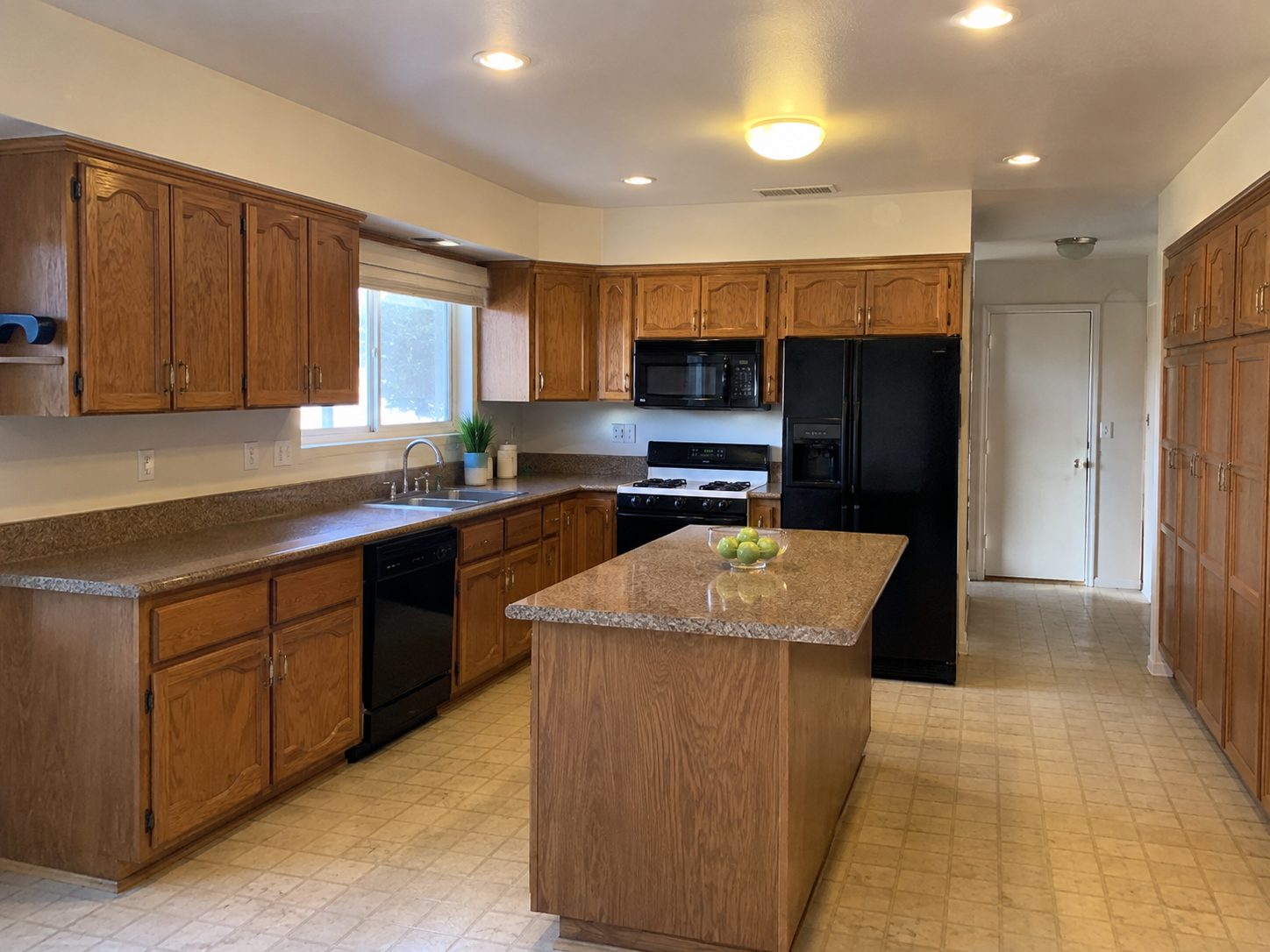 Kitchen before remodel with oak cabinet fronts and laminate counters, Dreamliner Construction